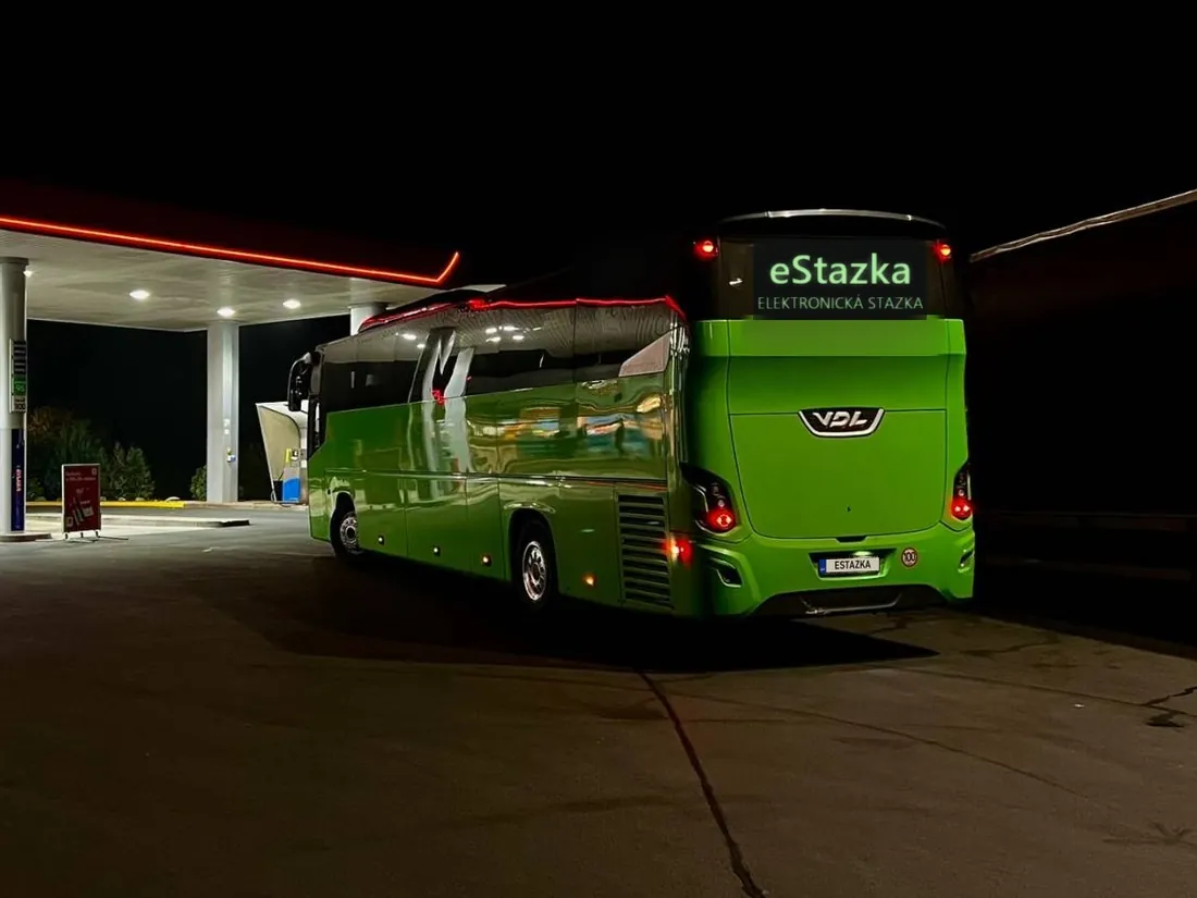 Zelený diaľkový autobus v noci na čerpacej stanici