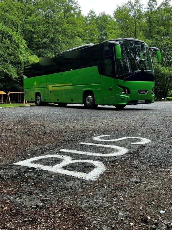 Zelený autobus pri vodorovnom značení BUS